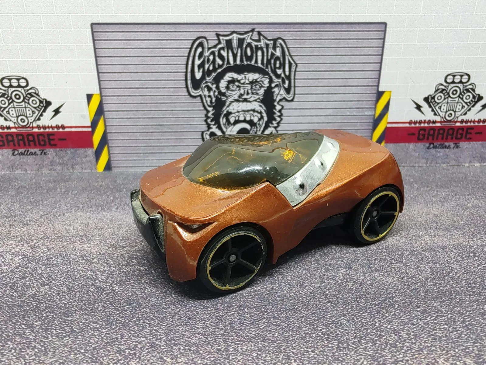 Supdogg — auto compacto de fantasía color cobrizo, cúpula ahumada y llantas negras con aro dorado