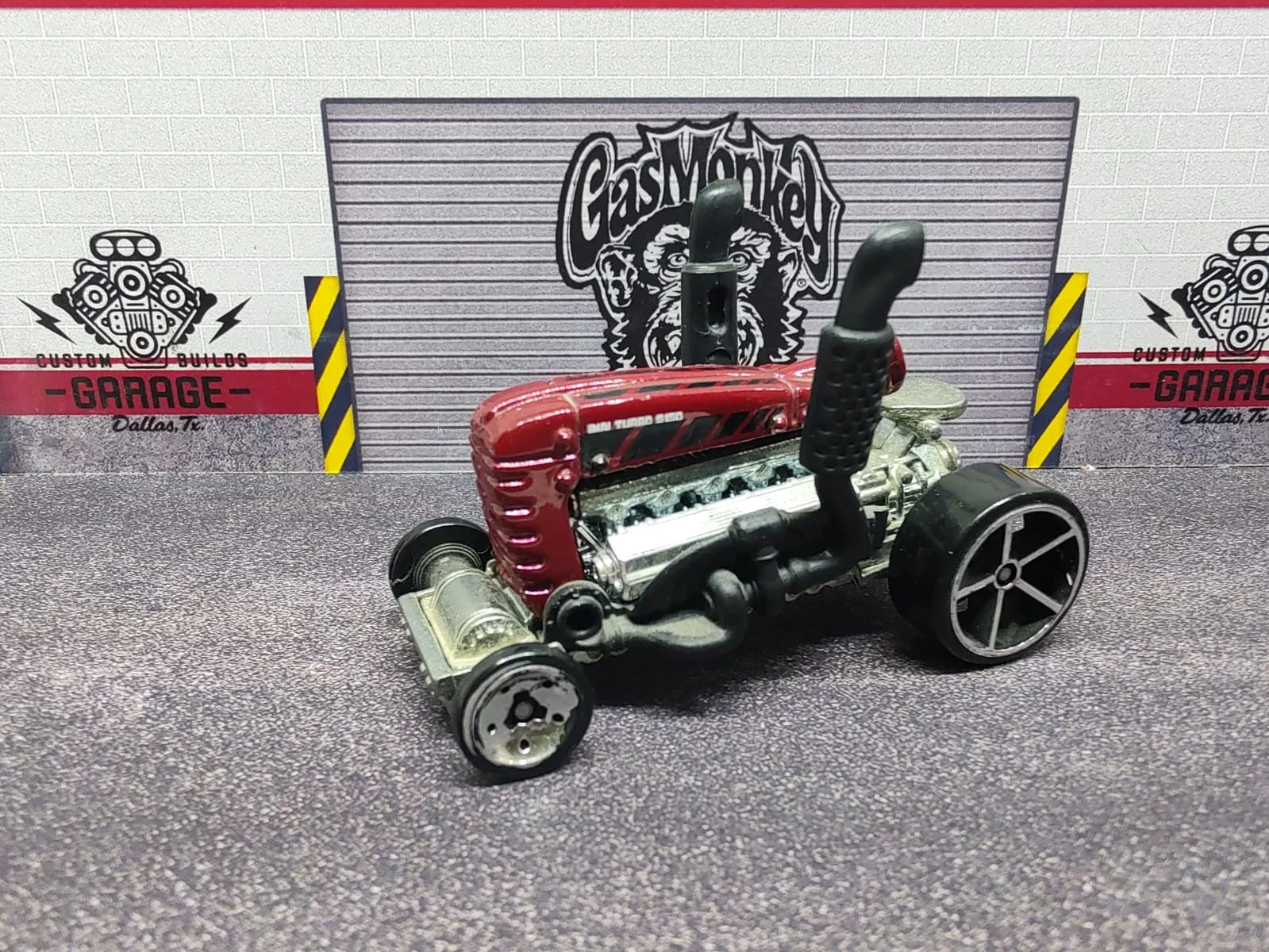Dragtor — tractor dragster rojo con motor plateado, escapes negros elevados y ruedas traseras grandes