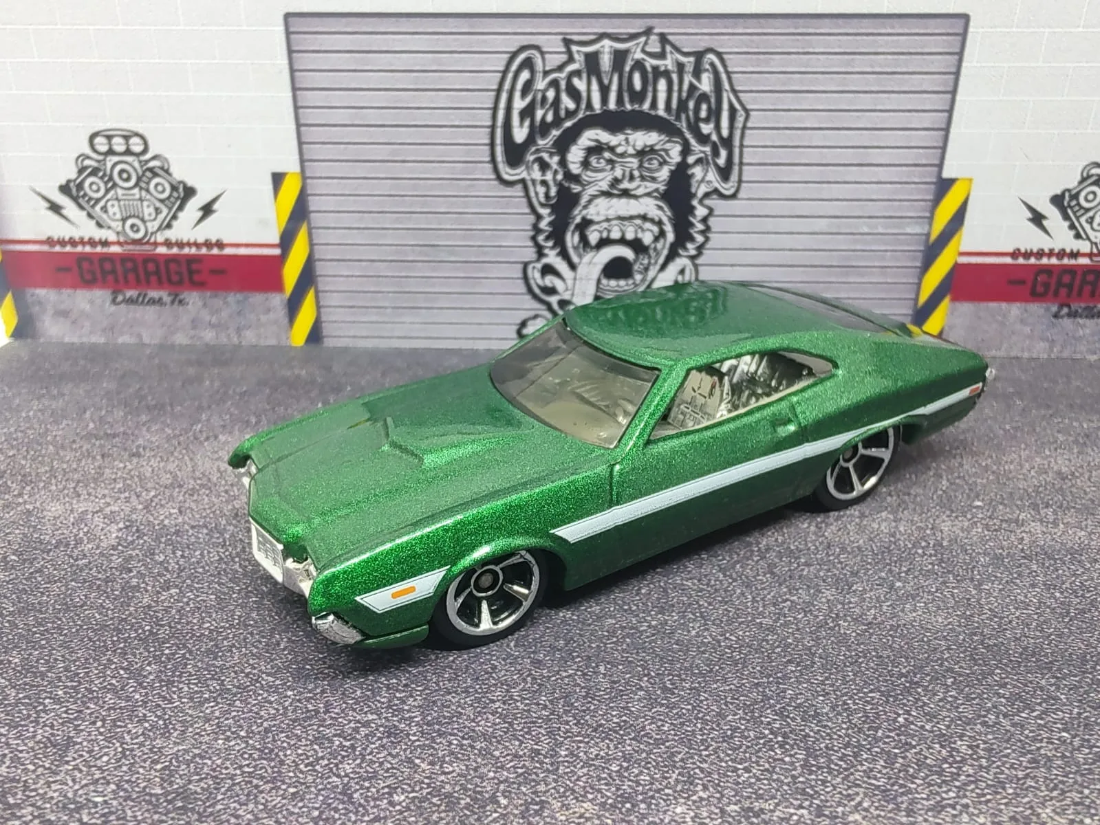 ’72 Ford Gran Torino Sport — verde metalizado con franja lateral blanca y llantas negras de aro plateado