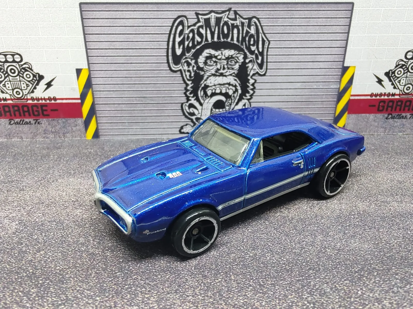 ’67 Pontiac Firebird 400 — azul metalizado con franjas claras y llantas negras de aro plateado