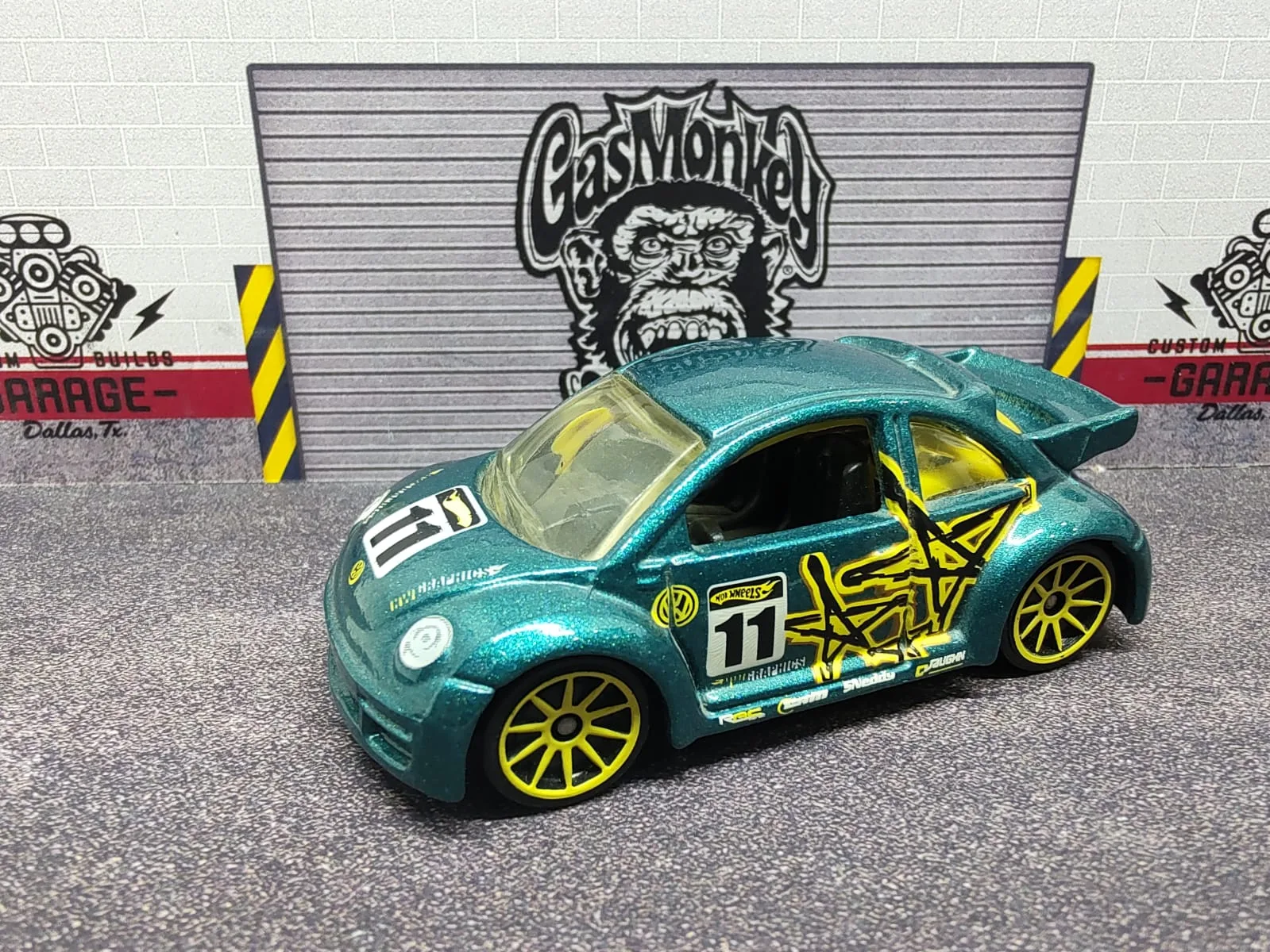 Volkswagen New Beetle Cup — verde azulado metalizado con llantas amarillas, alerón y número decorativo 11