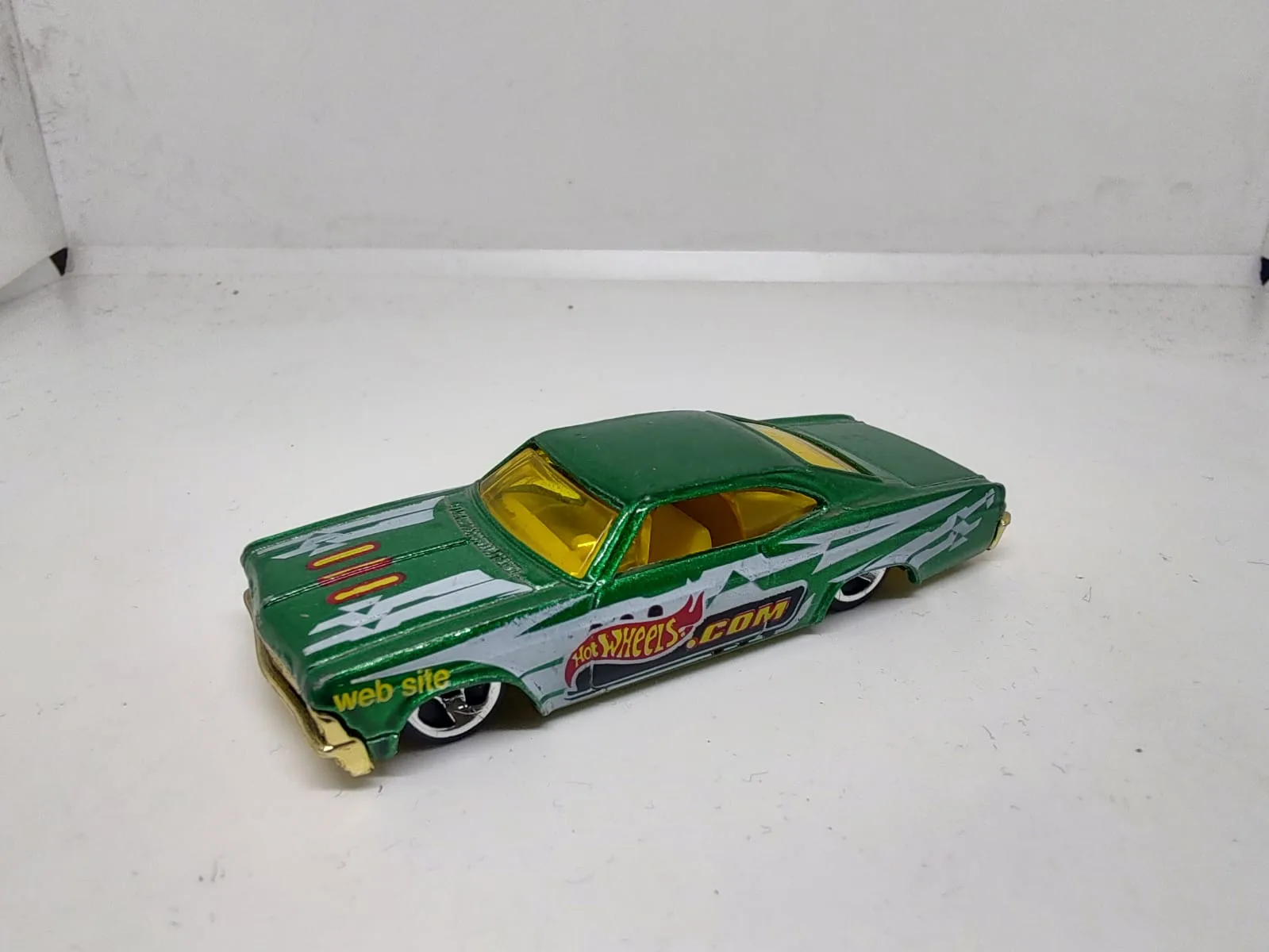 ’65 Chevy Impala — verde con decoración hotwheels.com y vidrios amarillos