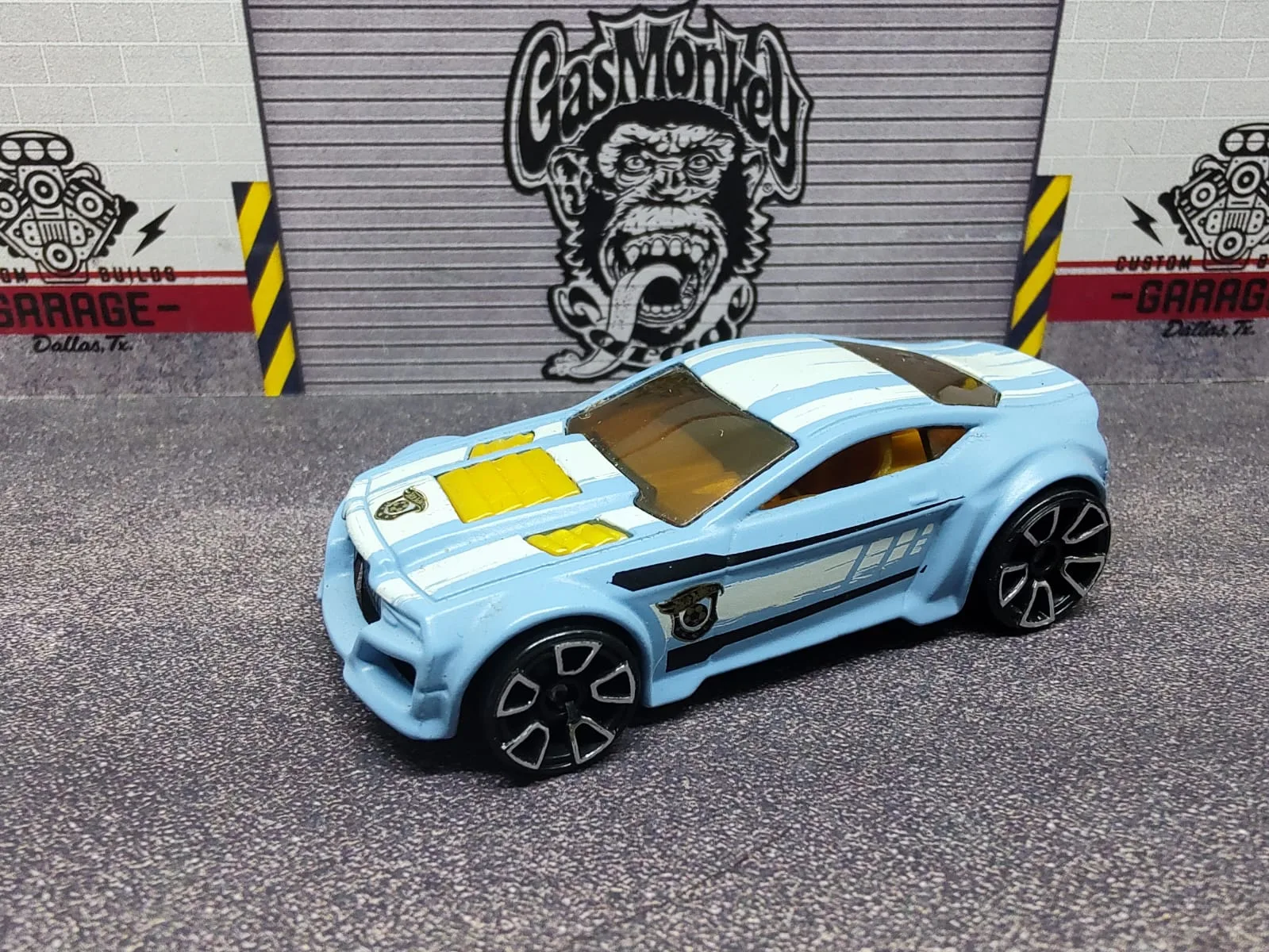 Torque Twister — coupé de fantasía celeste con franjas blancas, detalles amarillos y ruedas sobredimensionadas