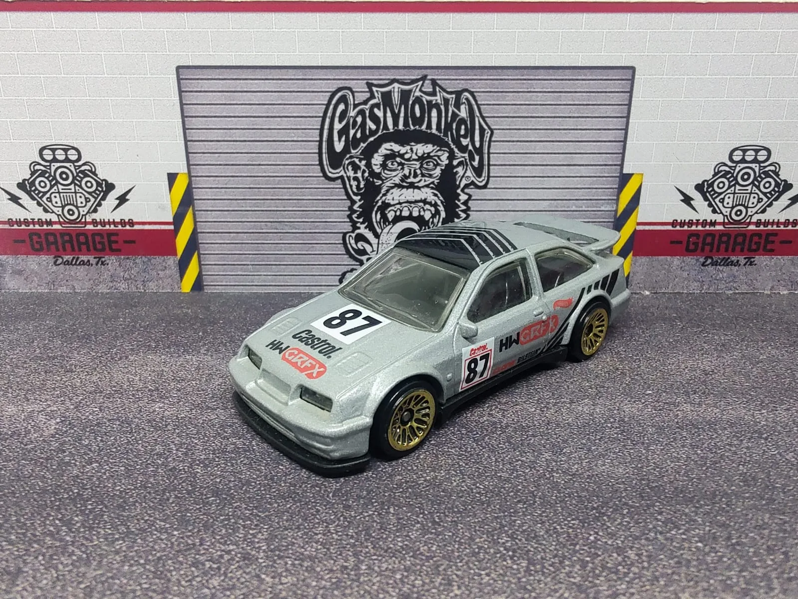 ’87 Ford Sierra Cosworth — gris claro con gráficas negras y rojas y número decorativo 87