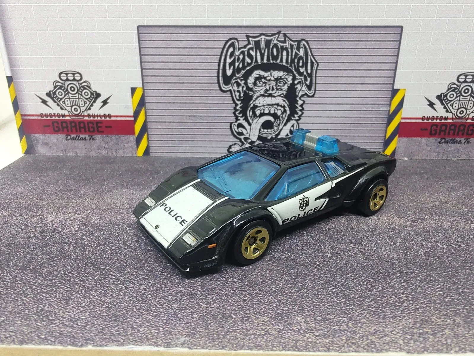 Lamborghini Countach Police Car — negro y blanco con decoración policial, luces azules en el techo y alerón negro