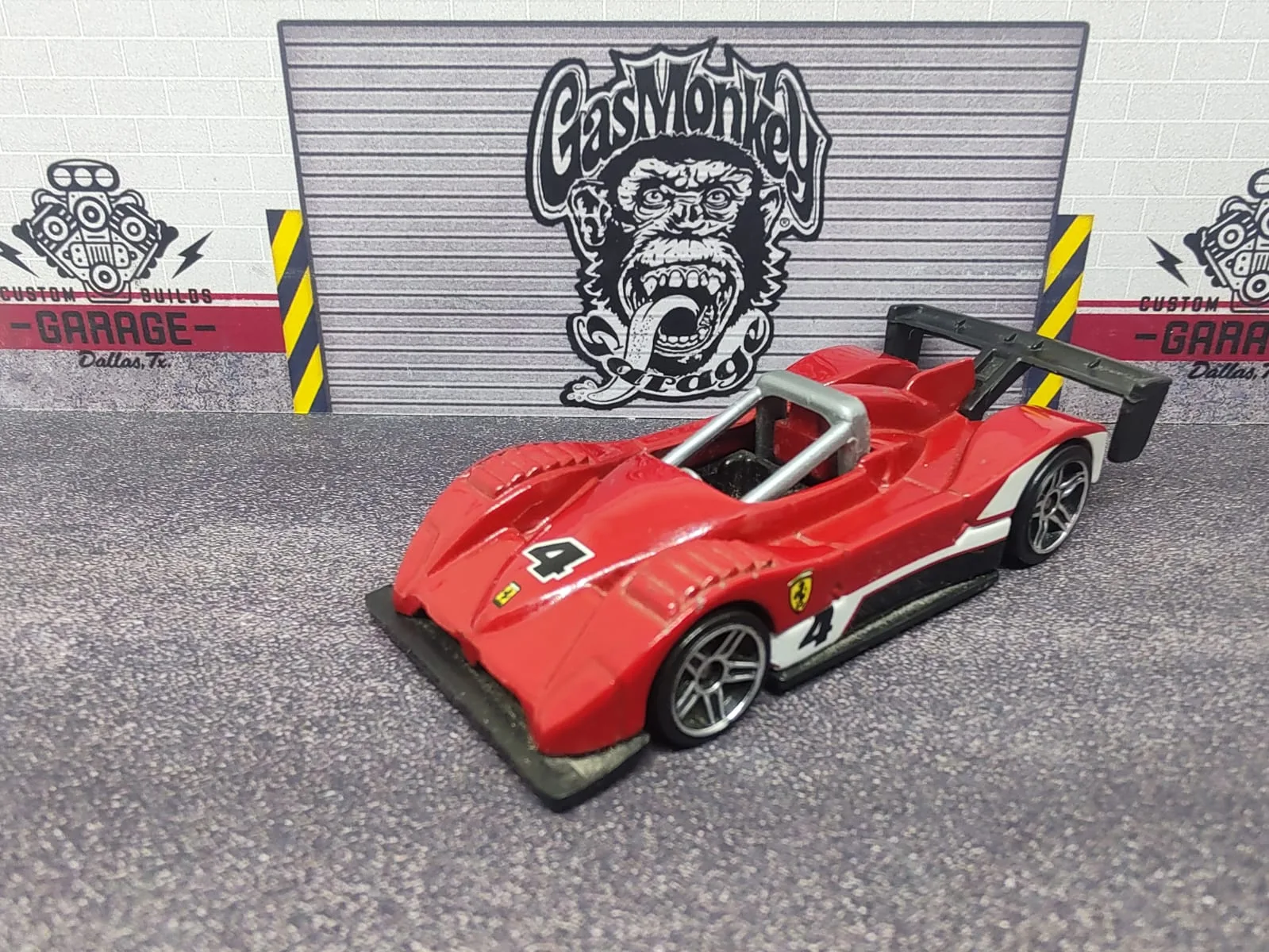 Ferrari 333 SP — rojo con detalles blancos y negros, alerón negro y número decorativo 4