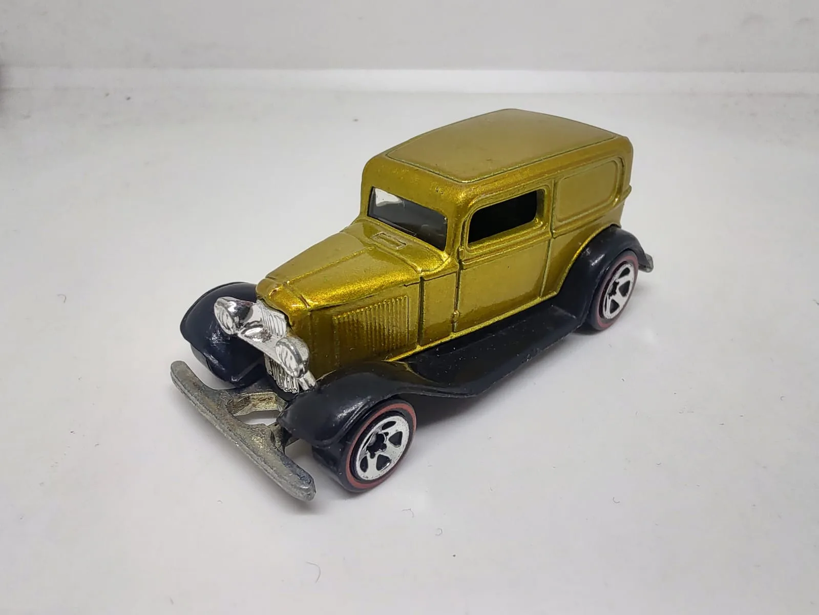 ’32 Ford Delivery — dorado con guardabarros negros y llantas de aro rojo