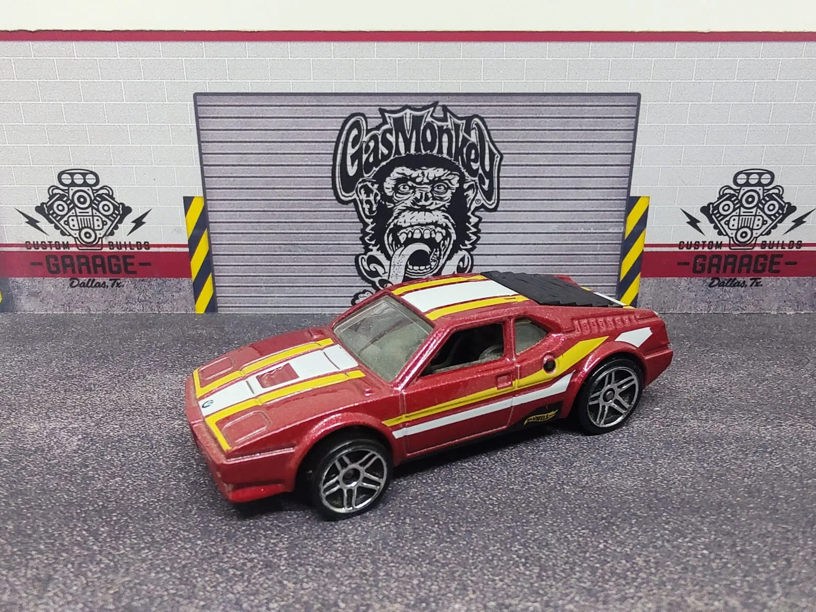 BMW M1 — rojo con franjas amarillas, blancas y negras