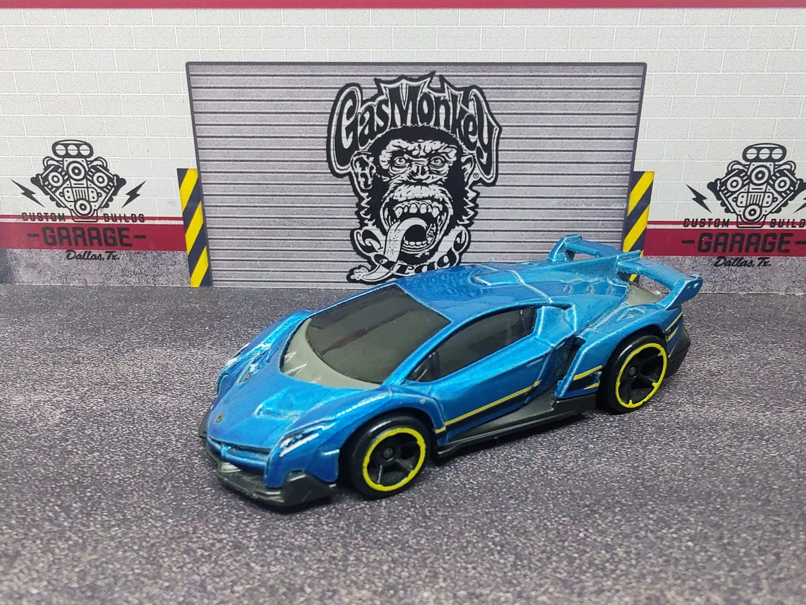 Lamborghini Veneno — azul metalizado con franjas amarillas y llantas negras de aro amarillo