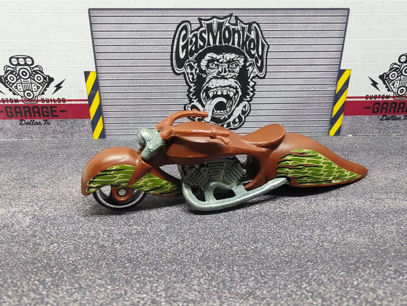 W-Oozie — moto alargada color cobrizo con llamas amarillas y verdes y motor plateado