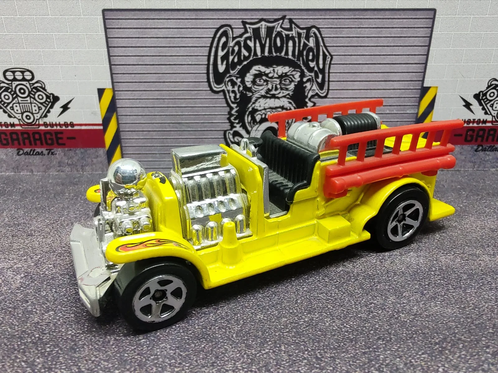 Old Number 5.5 — camión de bomberos amarillo con escalera roja y motor plateado expuesto