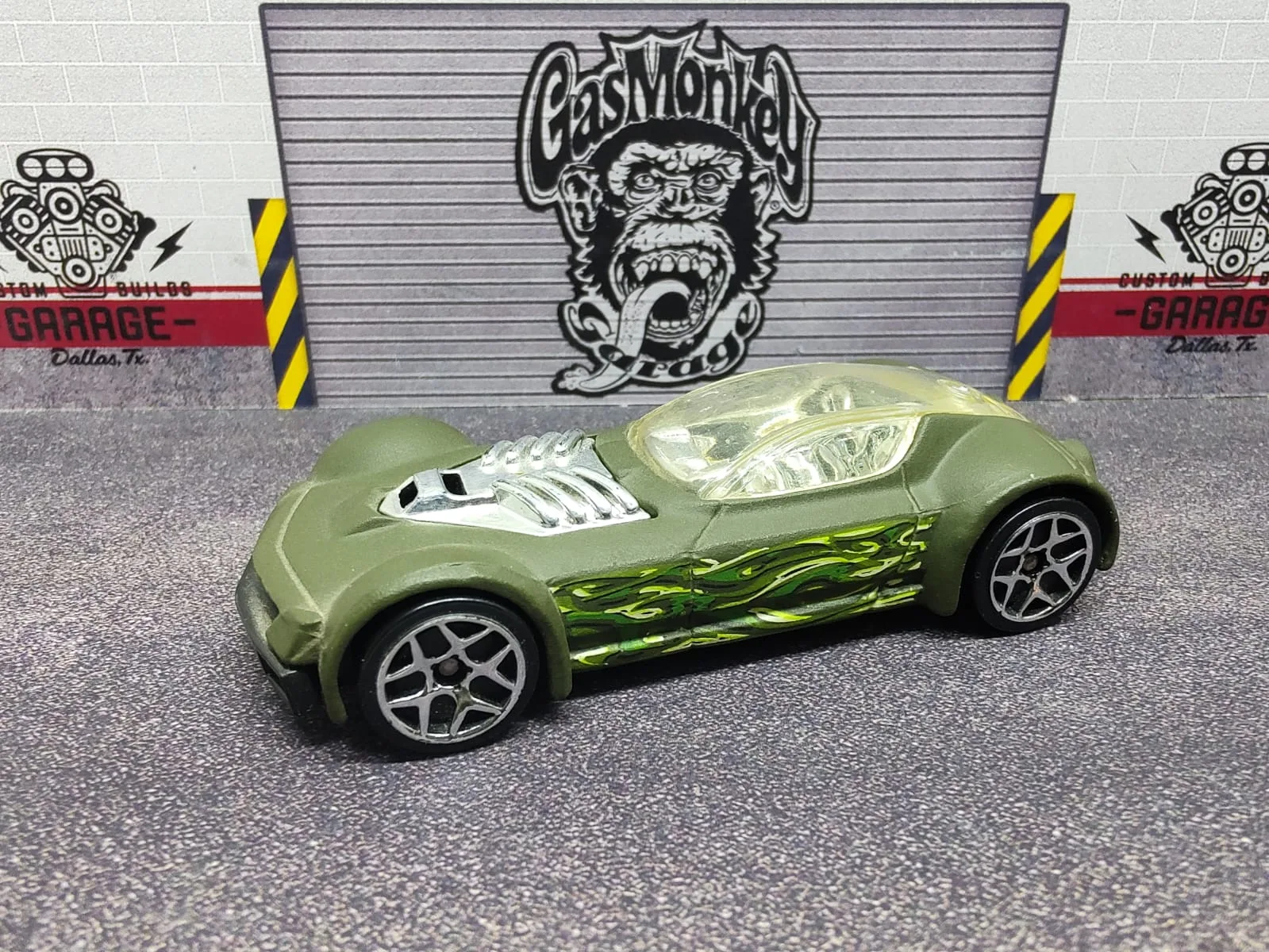 Ballistik — deportivo de fantasía verde oliva con llamas verdes, cúpula clara y motor plateado