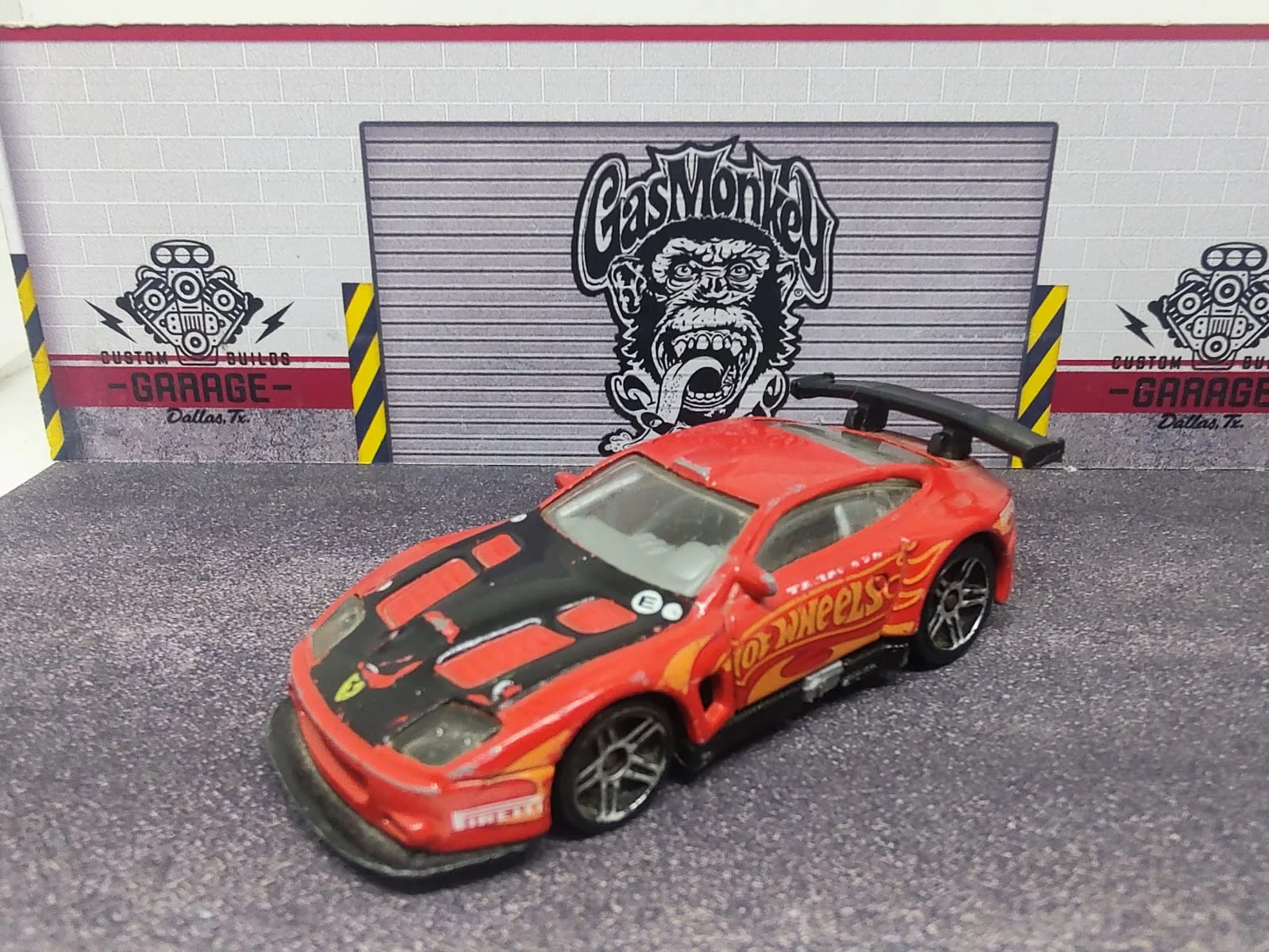 Ferrari 575 GTC — rojo con capó negro, logo Hot Wheels amarillo y decoración de competición