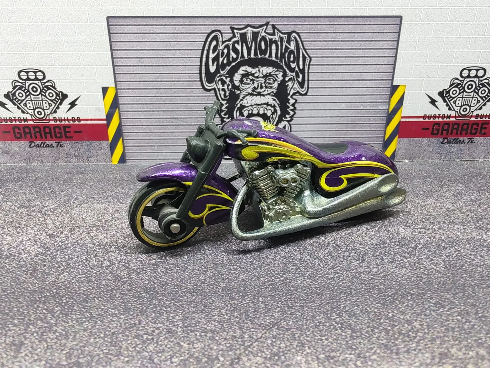 Scorchin’ Scooter — moto tipo chopper violeta con llamas amarillas y motor plateado