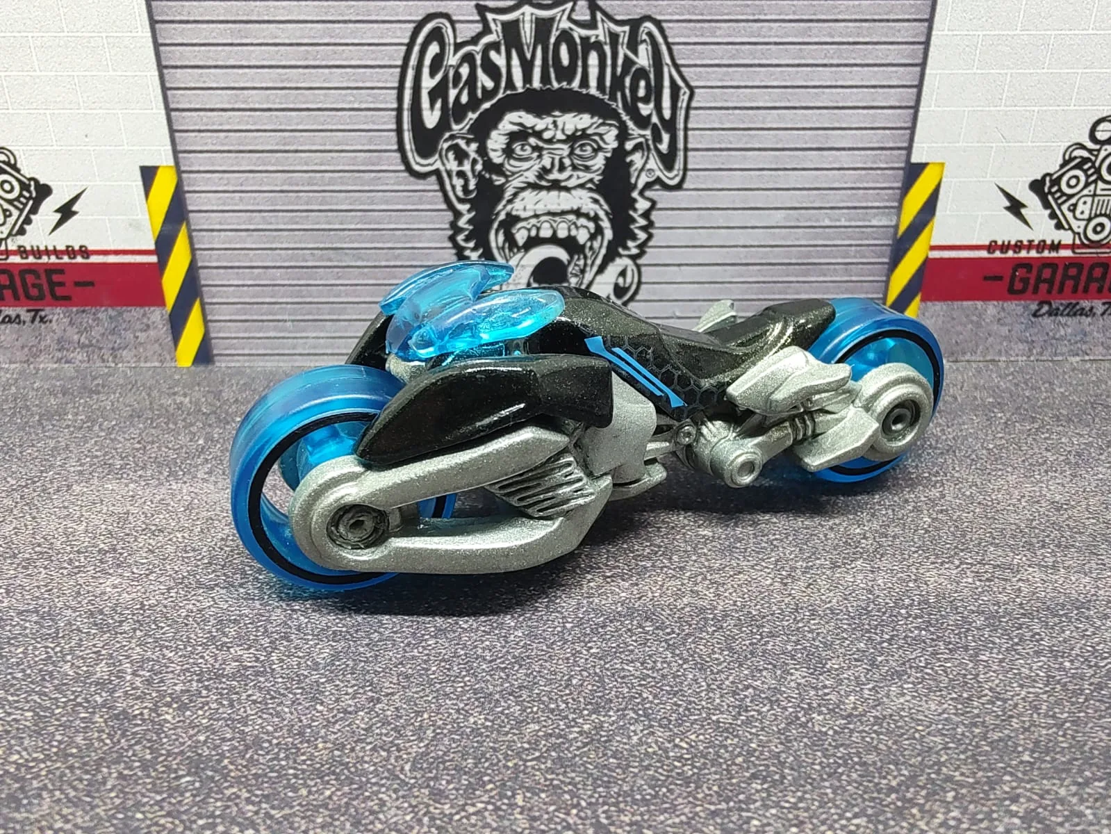 Max Steel Motorcycle — moto futurista azul y negra con estructura plateada y ruedas azules