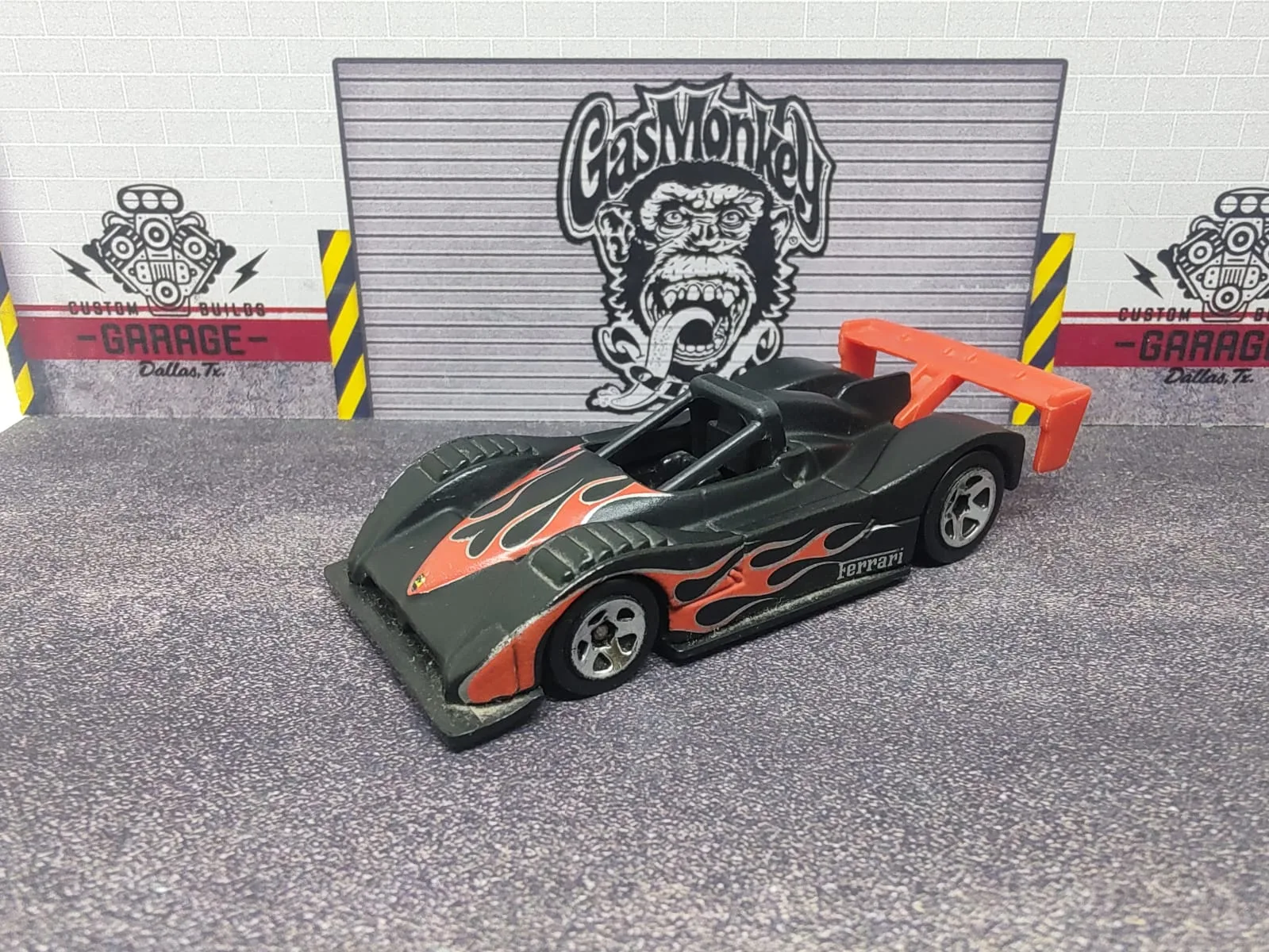 Ferrari 333 SP — gris oscuro con llamas naranjas, arco negro y alerón naranja