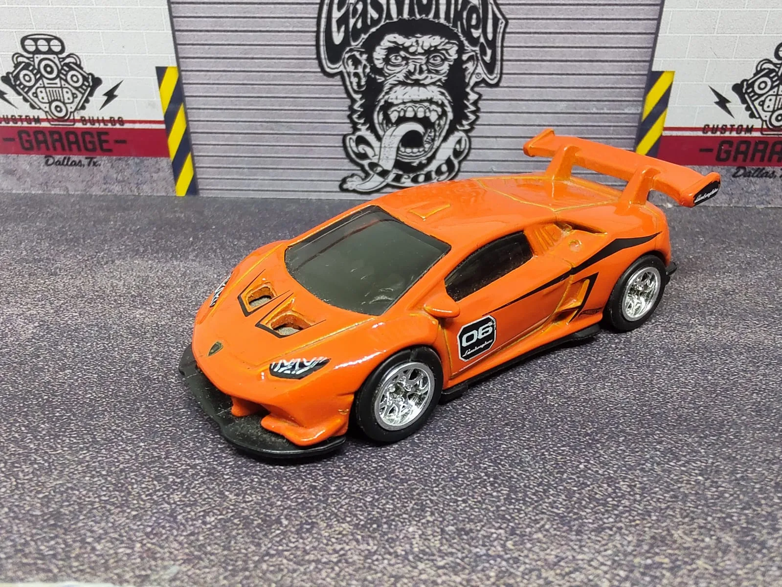 Lamborghini Huracán LP 620-2 Super Trofeo — naranja con detalles negros, número 06, alerón naranja y llantas plateadas