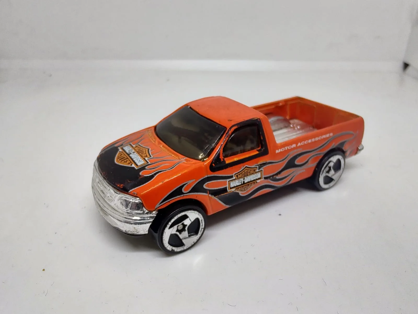 Ford F-150 — pickup naranja con llamas grises y decoración Harley-Davidson