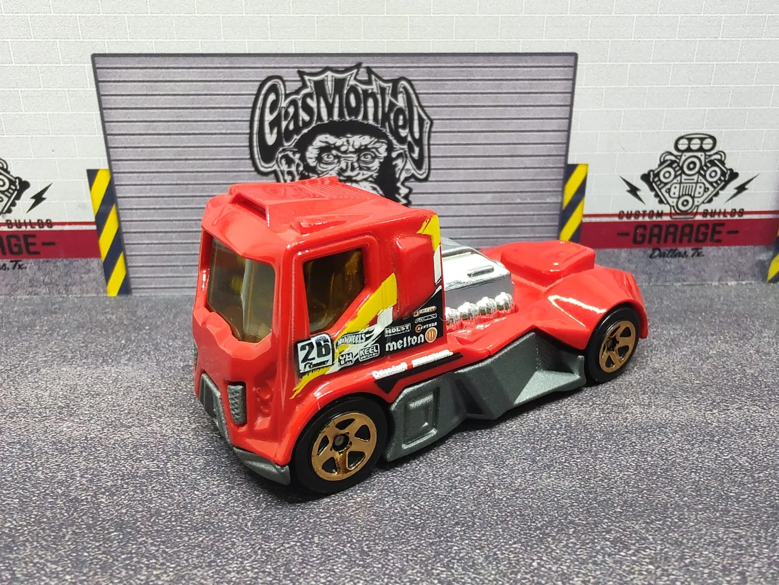 Rennen Rig — camión de cabina roja con motor expuesto, chasis gris y número decorativo 26