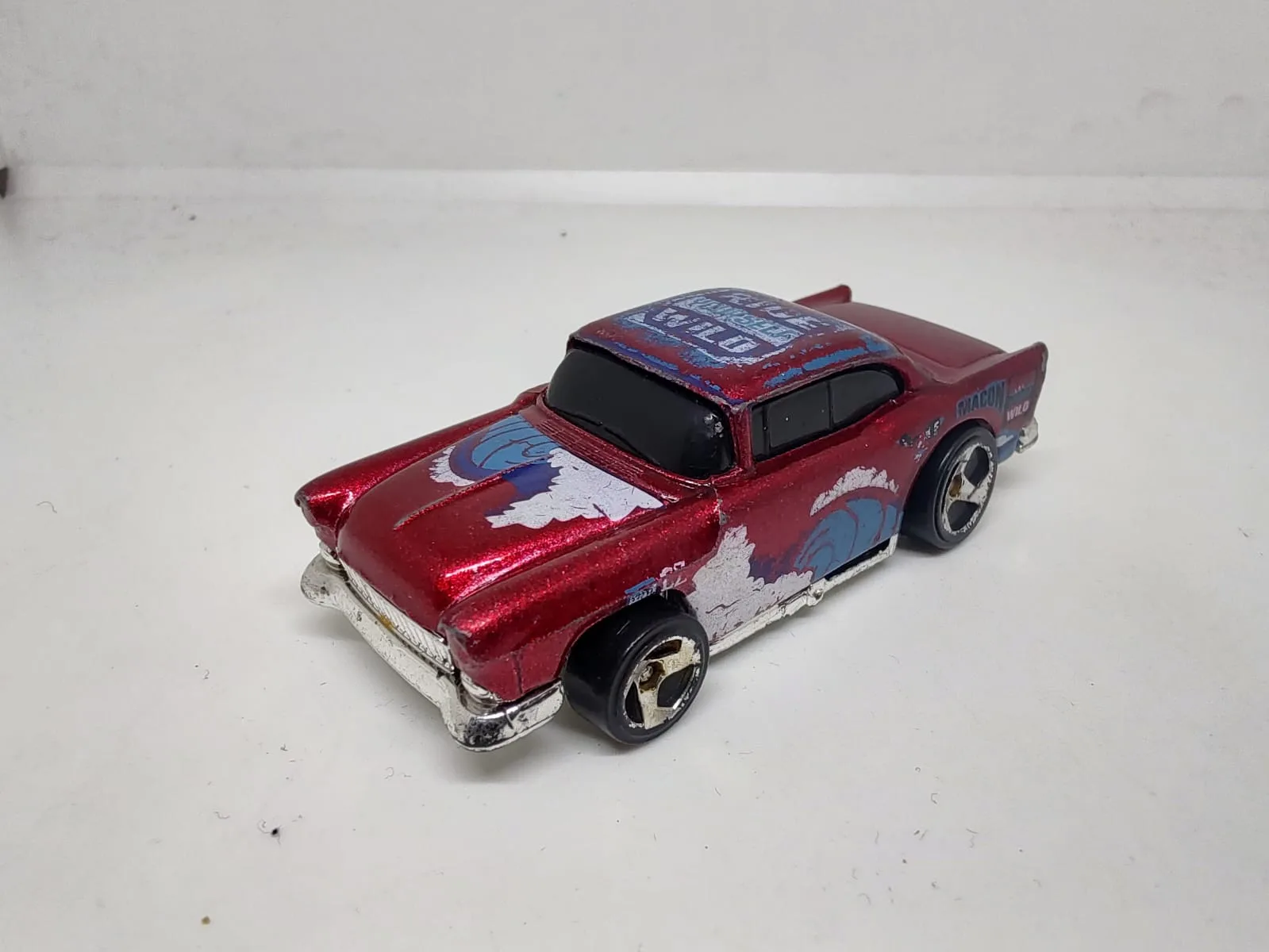 ’55 Chevy — rojo con gráfica Ride Yourself Wild y desgaste visible de pintura