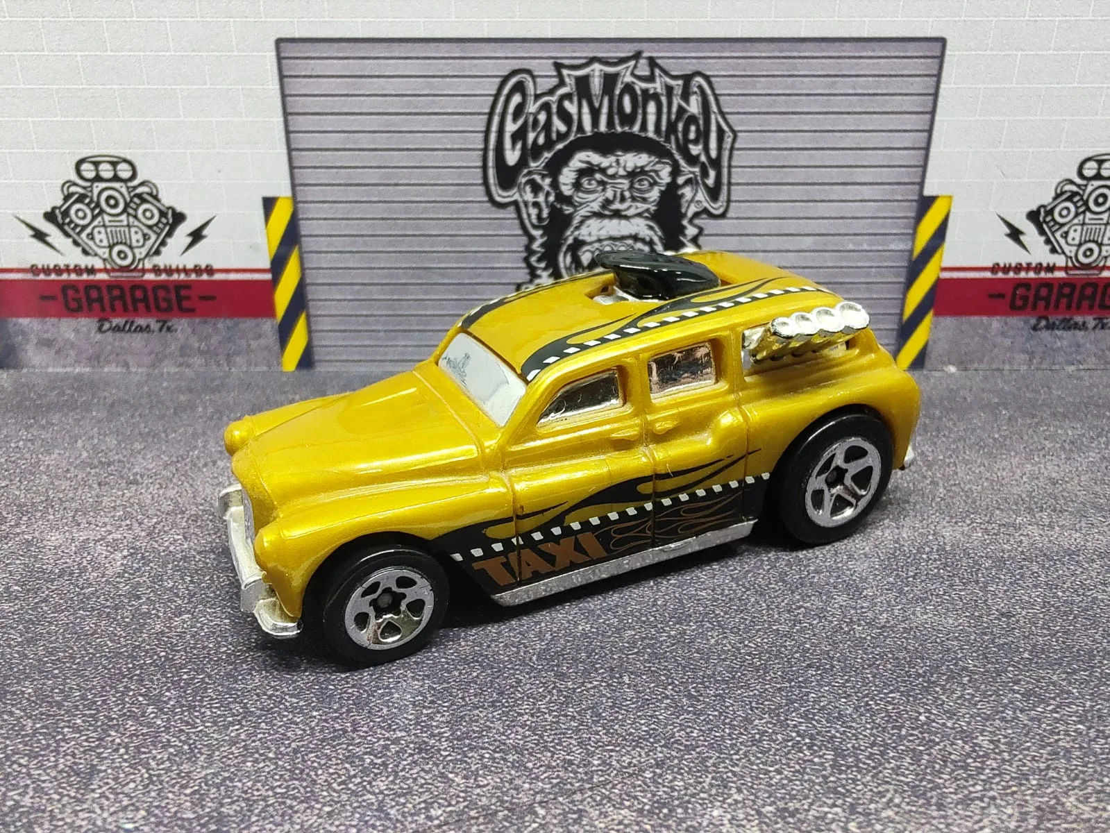 Cockney Cab II — taxi amarillo de estilo clásico con cartel TAXI en el techo y motor expuesto