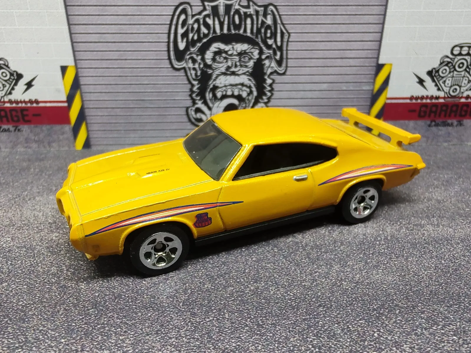 ’70 Pontiac GTO Judge — amarillo con detalles laterales naranjas y alerón trasero