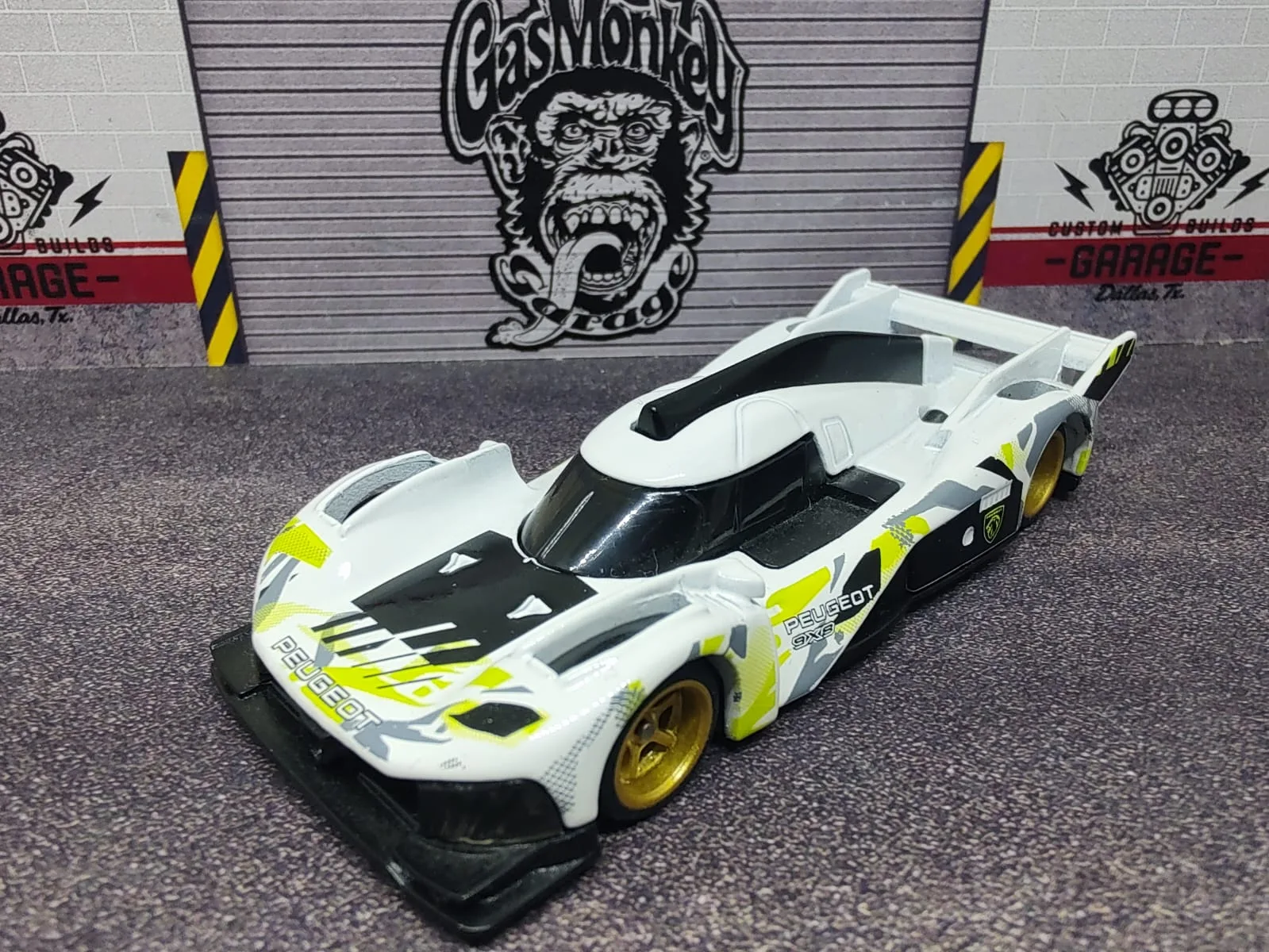 Peugeot 9X8 Hypercar — blanco con gráficos negros y amarillo lima y llantas doradas