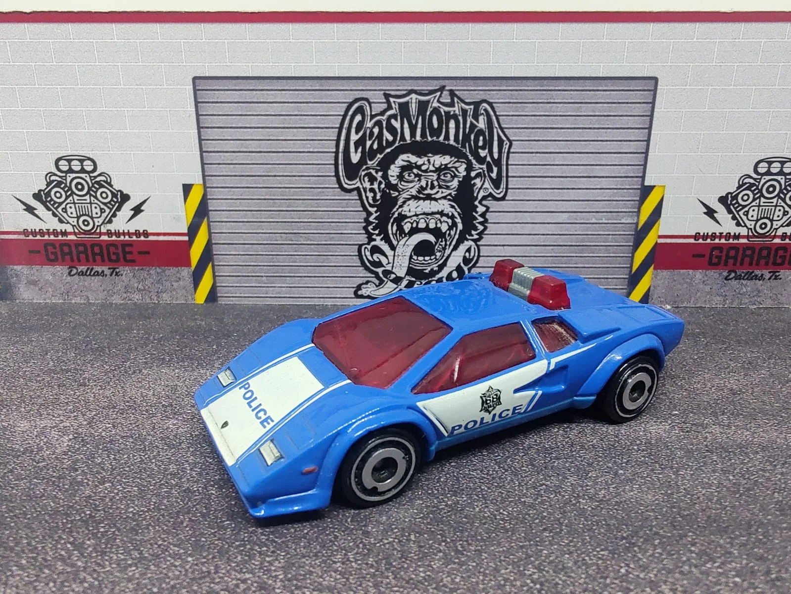 Lamborghini Countach Police Car — azul y blanco con decoración policial, luces rojas e interior rojo
