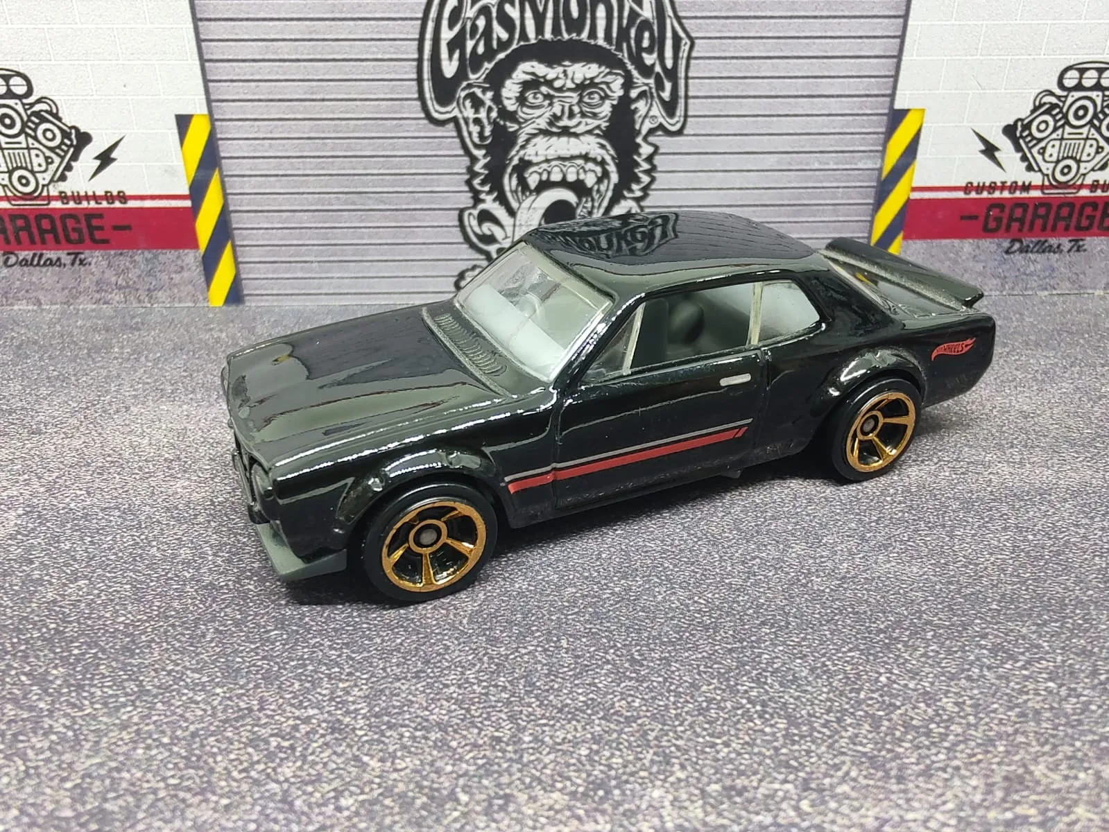 Nissan Skyline H/T 2000GT-X — negro con franja lateral roja y llantas de aro dorado