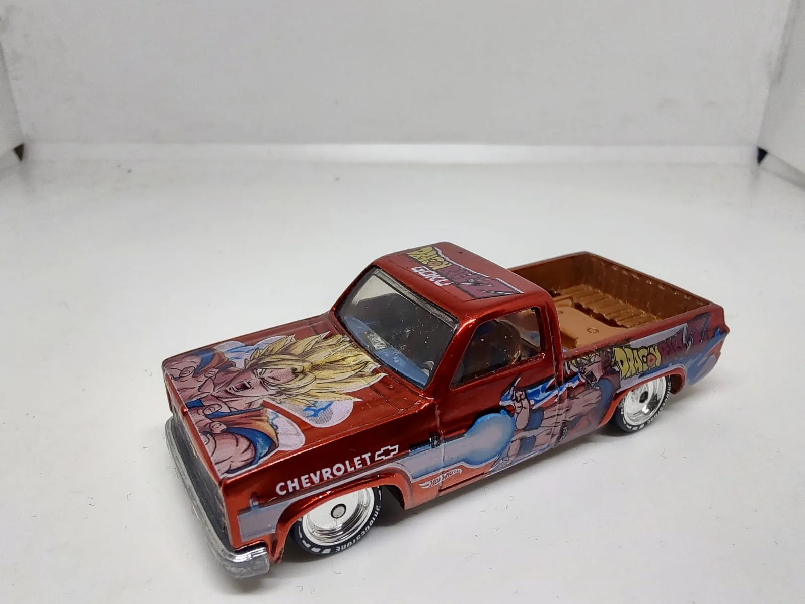 ’83 Chevy Silverado — pickup roja con gráficos multicolor de personajes; posible personalización