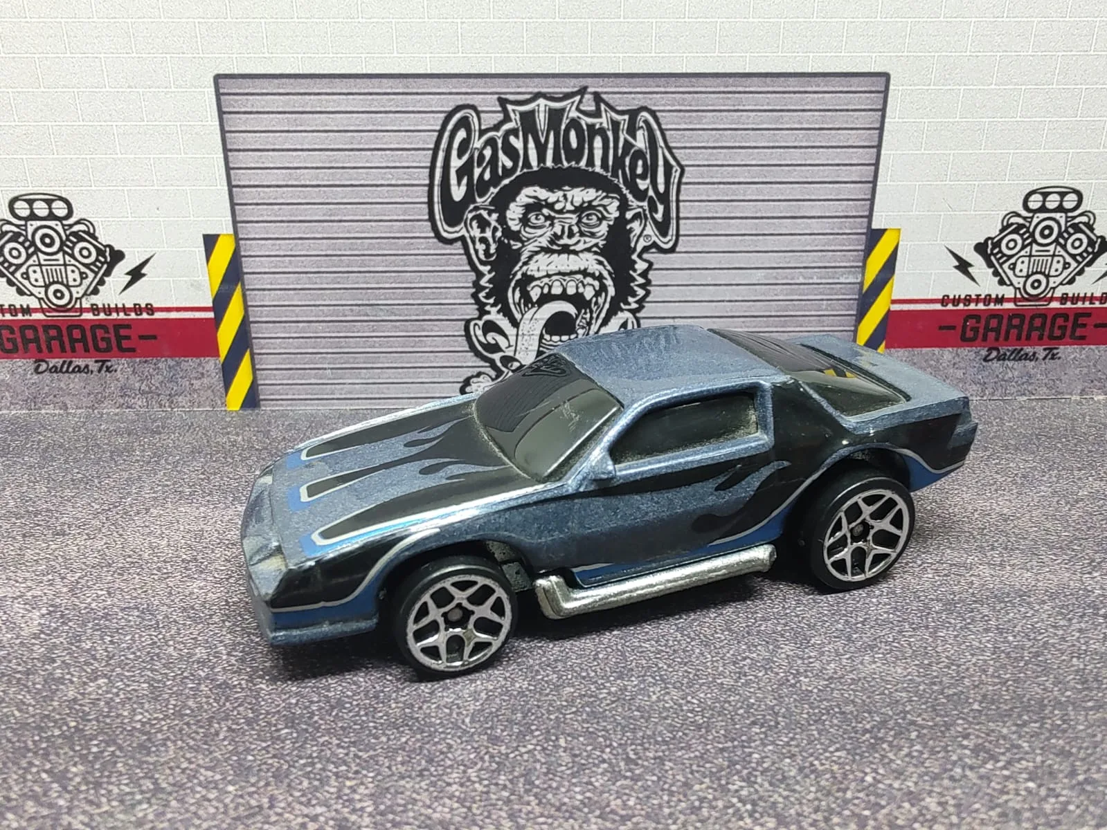 Blown Camaro (Camaro Z28) — azul grisáceo metalizado con llamas negras y escapes laterales plateados
